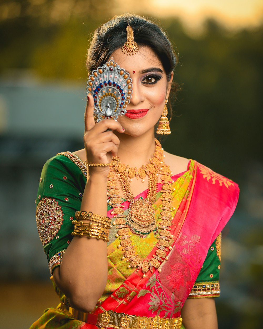 Woman in a green, gold and red saree